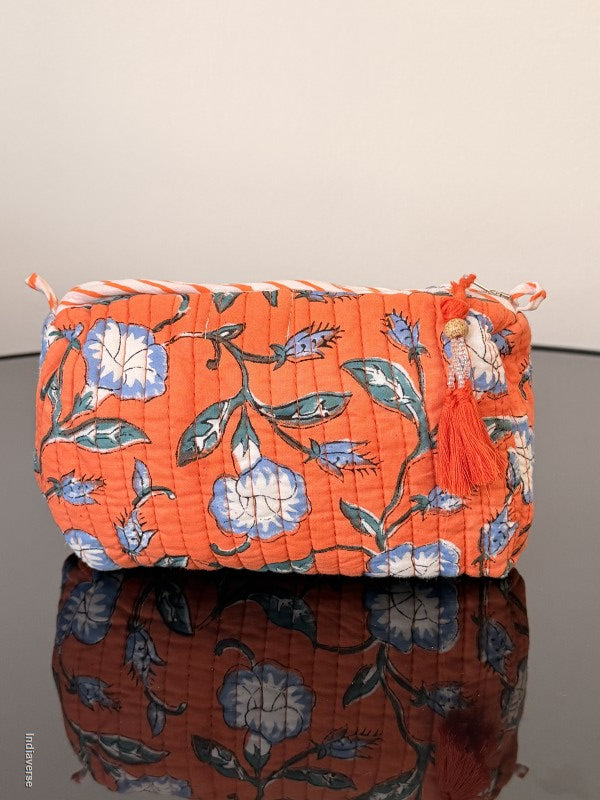 Two floral-patterned cushions, one orange and one brown, against a neutral background.