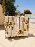 Textile bag with palm tree design on a tiled surface outdoors