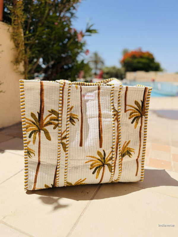 Textile bag with palm tree design on a tiled surface outdoors