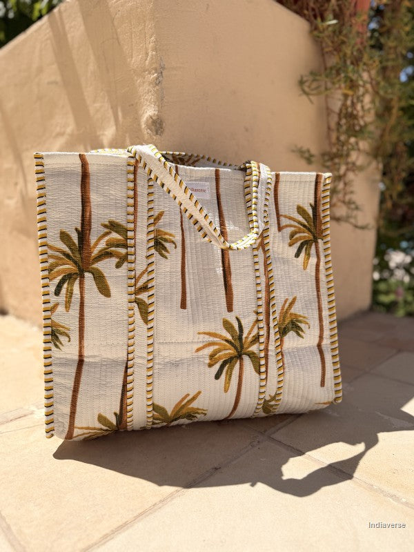 Tote bag with palm tree design on a stone surface