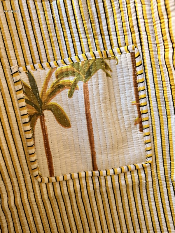 Close-up of a woven fabric with yellow and brown stripes and a floral pattern.