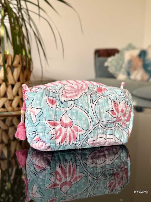 baby blue toiletry bag with pink lotus flowers sitting in a glass table in the living room | Aqua Lotus