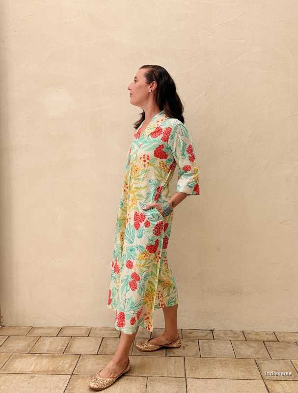 woman standing in front of a beige wall wearing a midi size summer dress