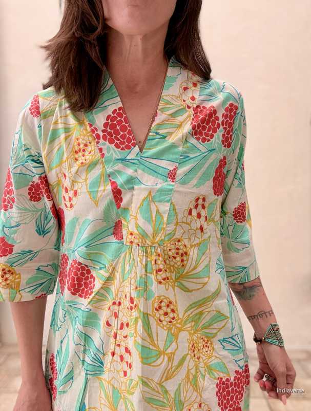 woman standing in front of a beige wall wearing a midi size summer dress