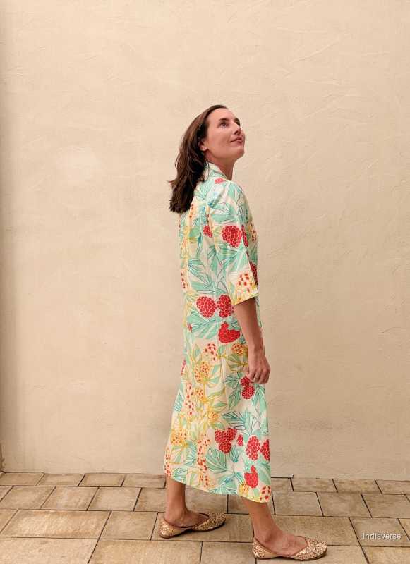 woman standing in front of a beige wall wearing a midi size summer dress