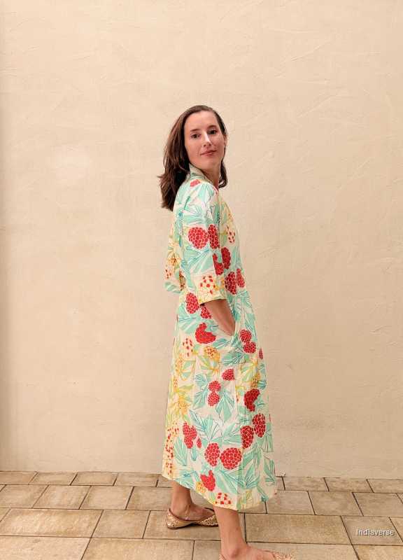 woman standing in front of a beige wall wearing a midi size summer dress