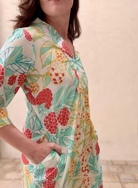 woman standing in front of a beige wall wearing a midi size summer dress