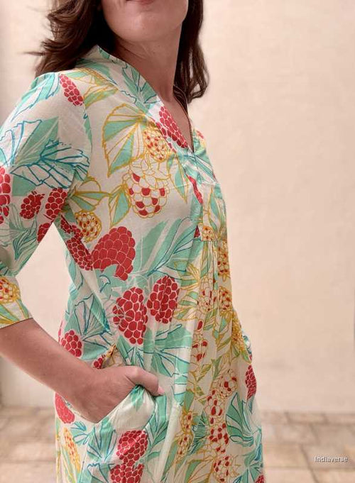 woman standing in front of a beige wall wearing a midi size summer dress