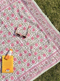 Patterned blanket with sunglasses and a book on grass