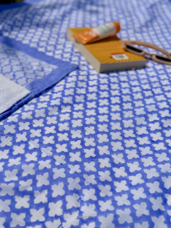 Blue fabric with white floral pattern and a book on top