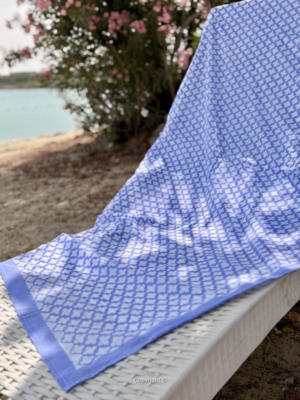 Blue patterned towel on a chair by a lakeside