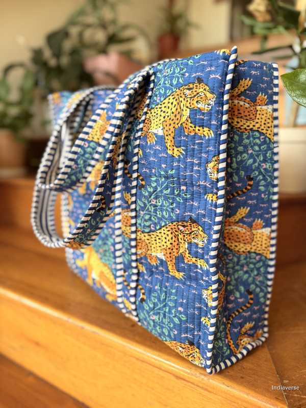Blue fabric bags with tiger patterns on a wooden surface