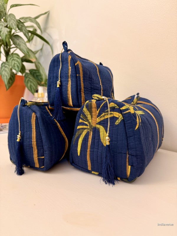 blue pouches with blue and golden tassels with palm tree design sitting on a white surface | Blue Palm
