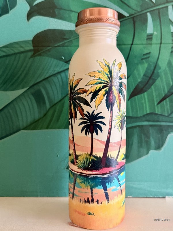 copper water bottle for drinking water with colorful palm tree oasis design in a desert on beige background standing in front of a green leaf wallpaper