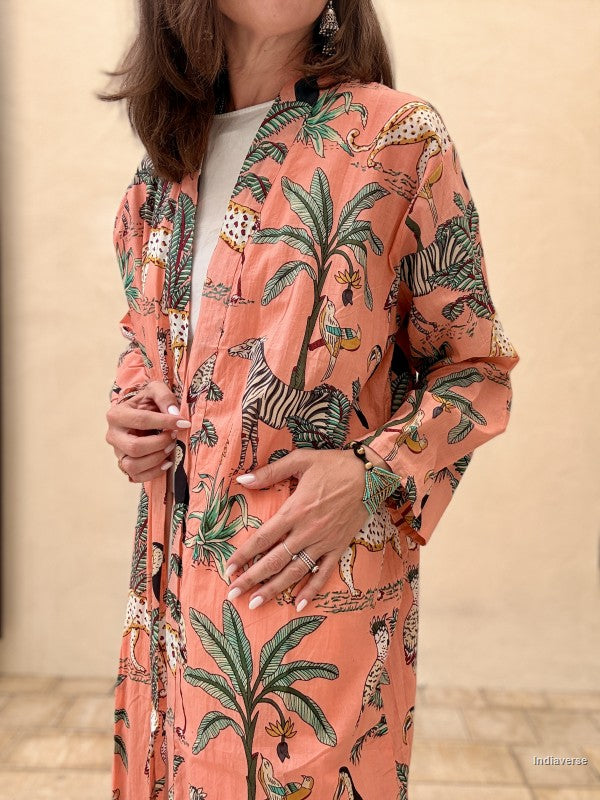 Person wearing a pink floral and animal print jacket against a beige background