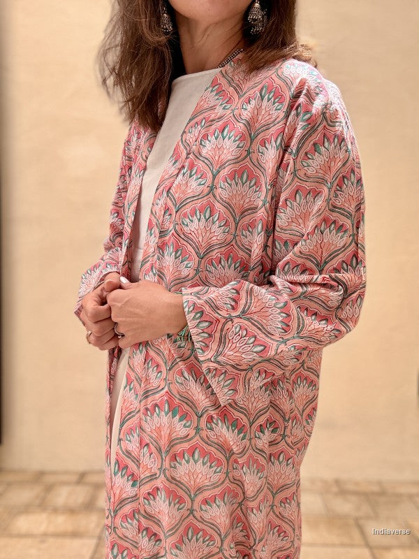 Person wearing a pink floral patterned outfit against a beige background
