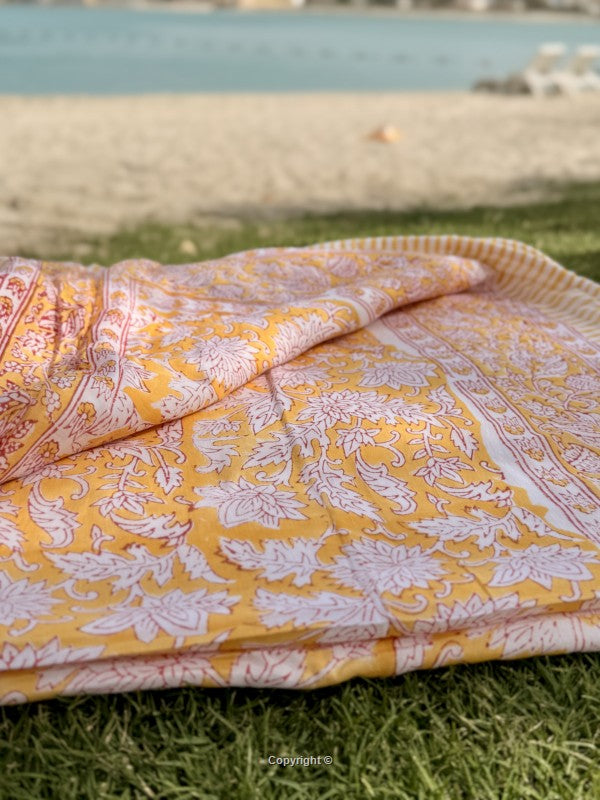 Yellow and white patterned fabric on grass with a blurred background