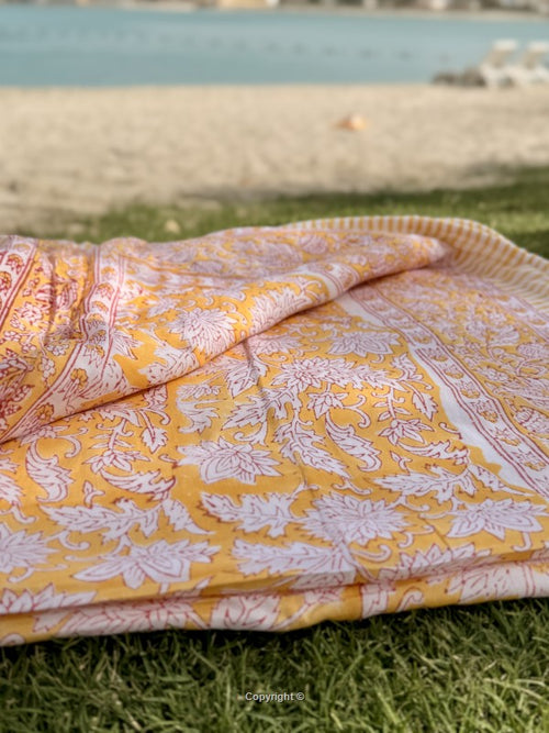 Yellow and white patterned fabric on grass with a blurred background