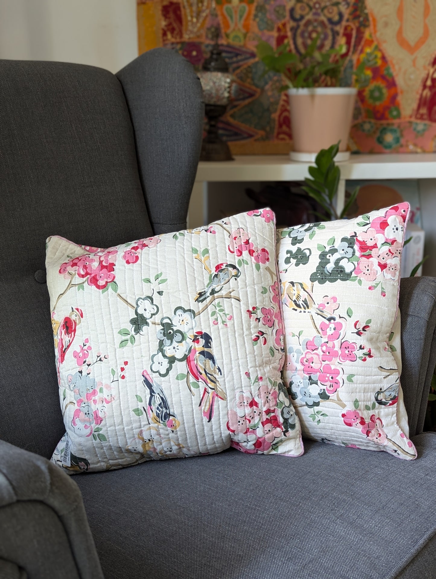 Cushion-cover-with-a-cream-base-and-with-colorful-birds-and -flower-blossom-design