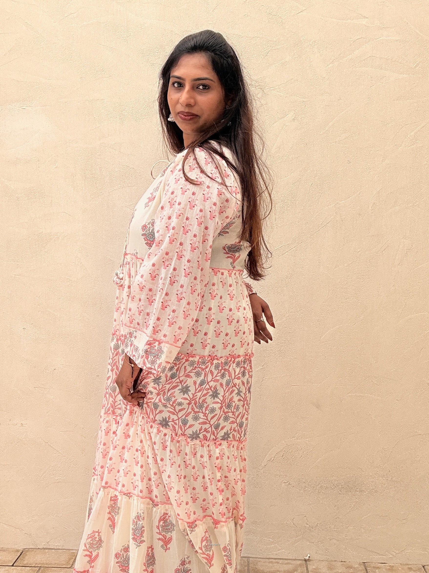 Woman wearing a floral outfit against a beige background