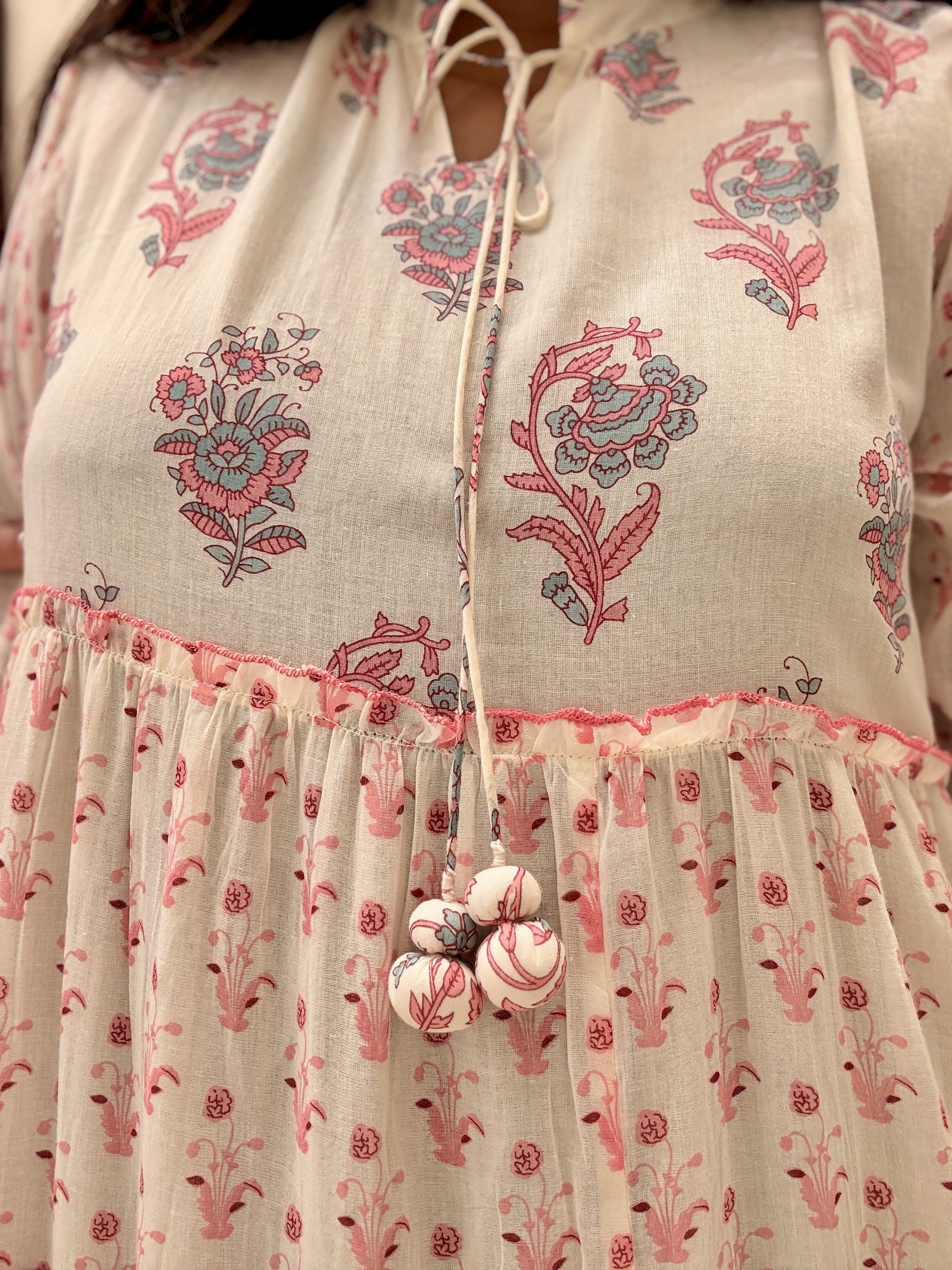 Close-up of a floral embroidered dress with a pink trim