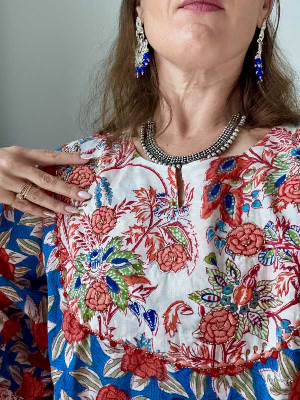 Close up of a woman wearing a colorful floral dress with intricate patterns