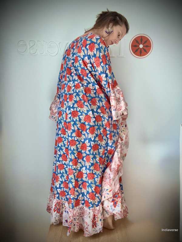 Woman wearing a floral dress with red and blue patterns against a plain background