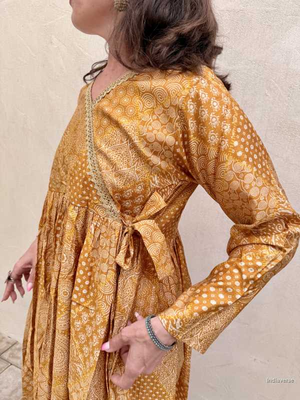 Woman wearing a yellow patterned dress against a neutral background