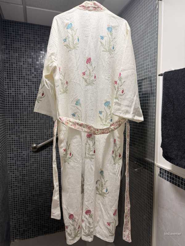 Embroidered white robe with floral patterns in a bathroom setting