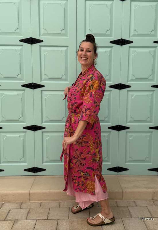 Model wearing a hot pink waffle cotton bathrobe with a relaxed fit, tie belt, and pockets, showcasing the lightweight and breathable fabric.