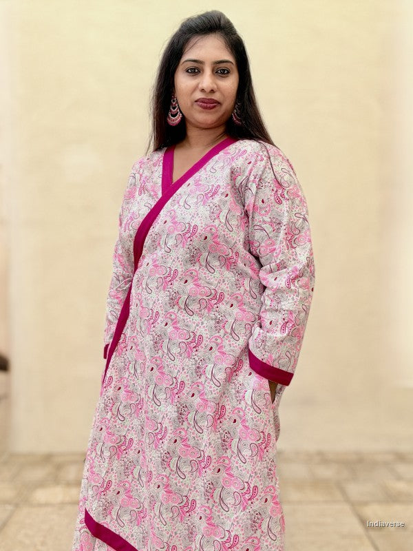 Woman wearing a pink and white patterned kurta with a plain background