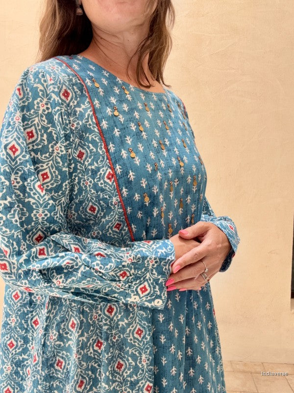 Woman wearing a blue patterned dress against a beige background
