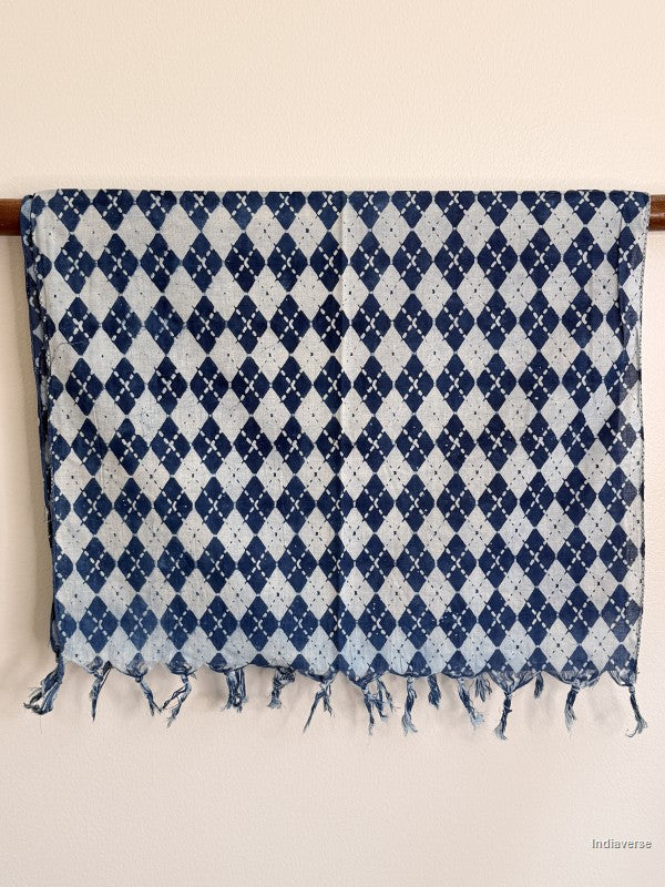 Blue and white patterned fabric with fringes on a beige background