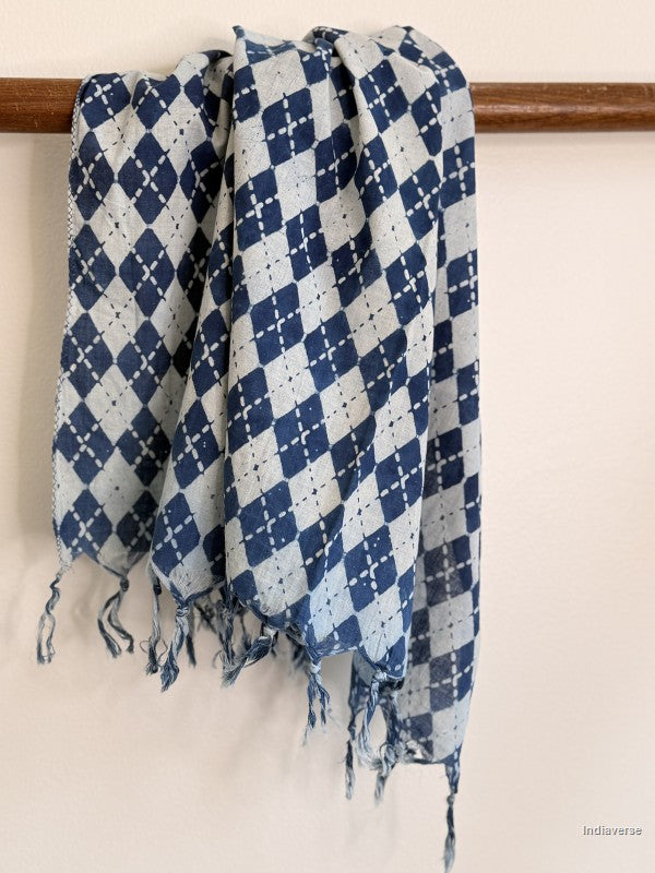 Blue and white checkered scarf with fringes on a wooden rod against a white background