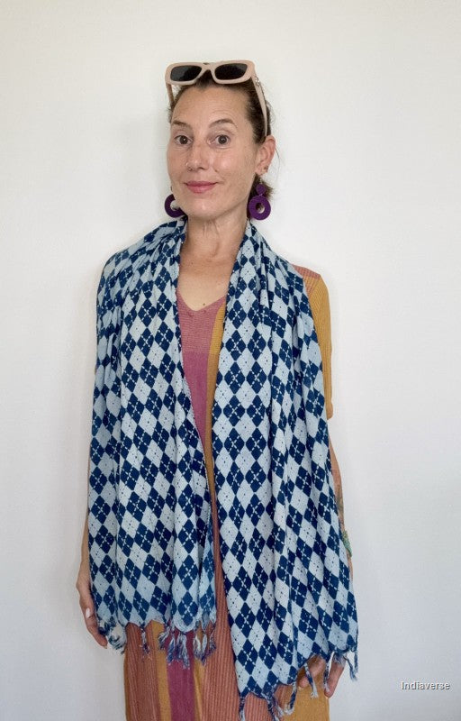 Woman wearing a blue and white patterned scarf against a white background