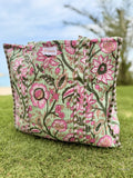 Floral-patterned pillow on grass with blurred background