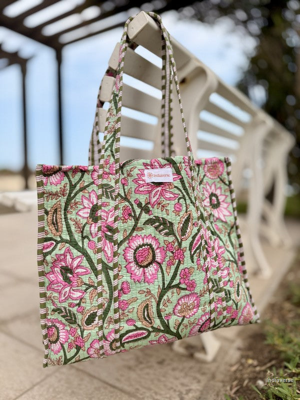 Floral patterned tote bag hanging on a wooden bench outdoors