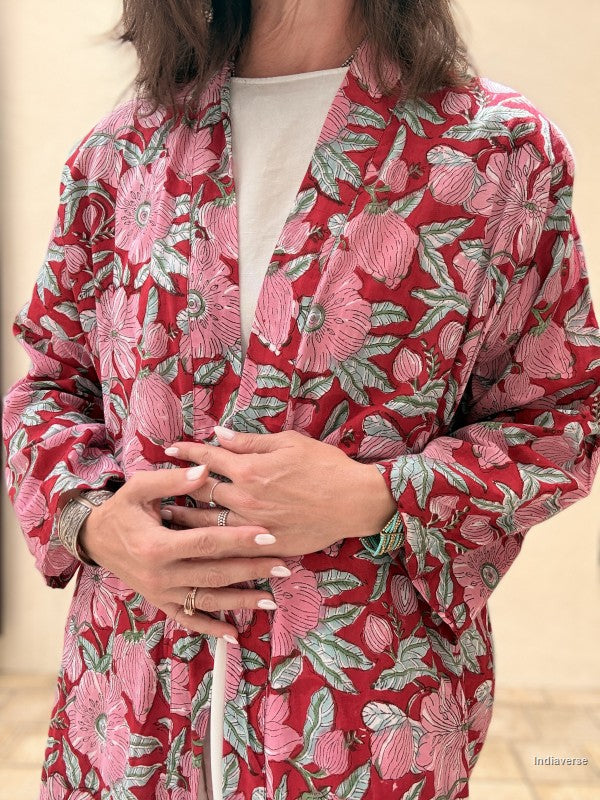 Person wearing a red floral patterned outfit with a neutral background