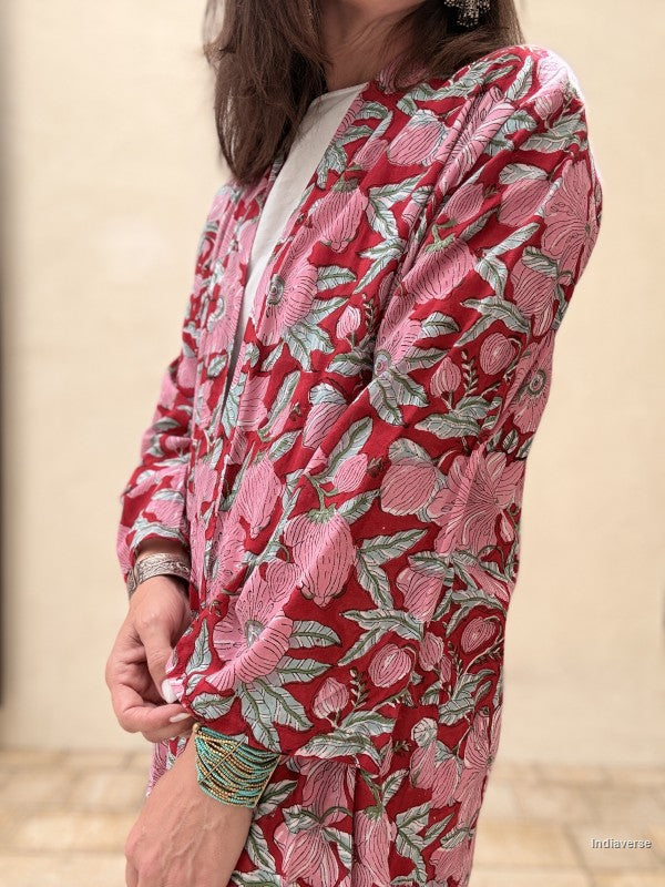 Person wearing a red floral patterned outfit with a neutral background