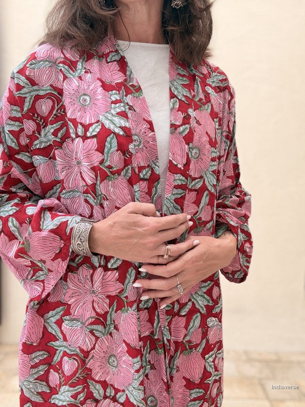 Red floral patterned garment worn by a person on a beige background
