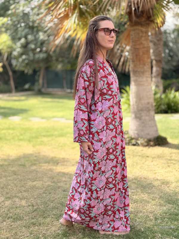 Woman wearing a pink floral dress standing in a park with trees and grass in the background