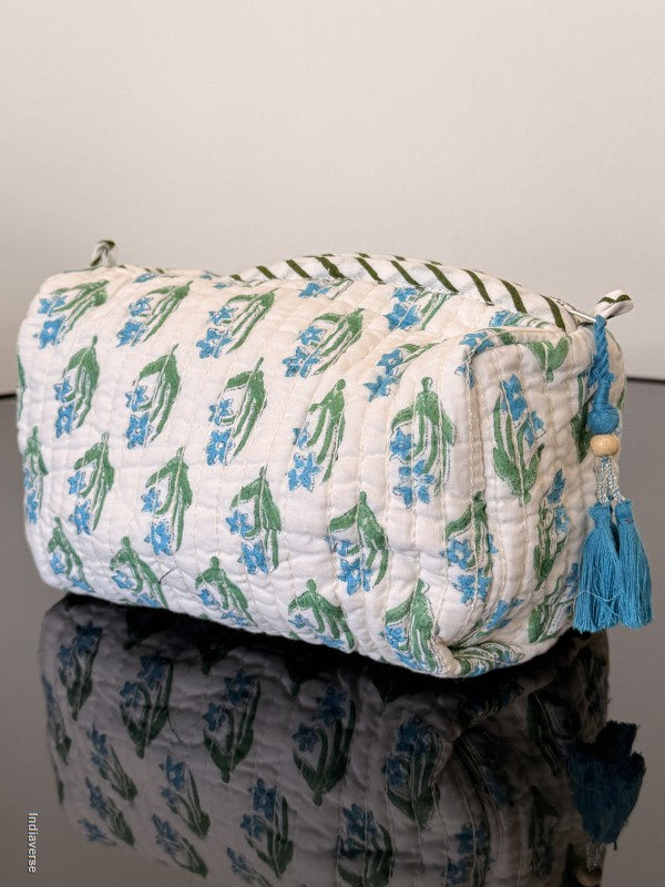 Floral-patterned fabric roll with tassels on a plain background