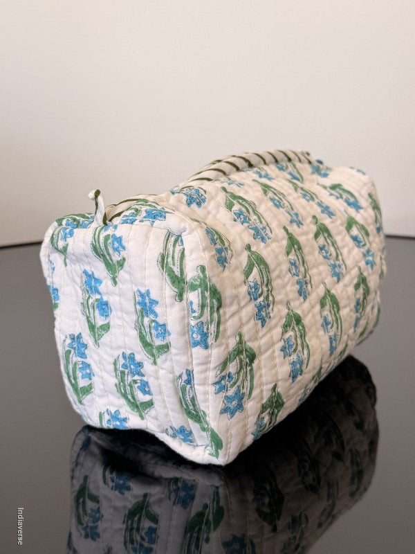 Floral-patterned quilt draped over a chair against a plain background