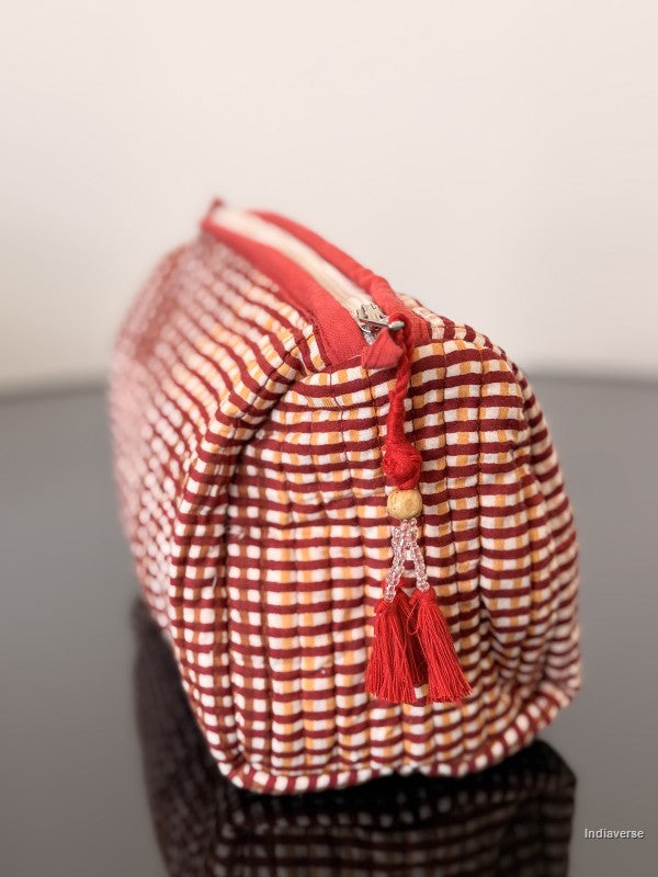 Red and white checkered bag with a tassel on a gray surface