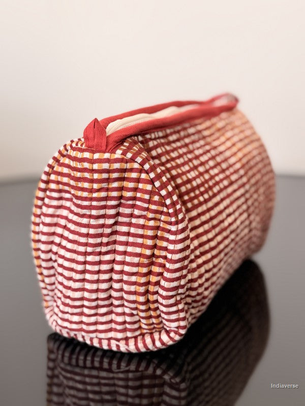 Red and white striped fabric roll on a reflective surface with a neutral background
