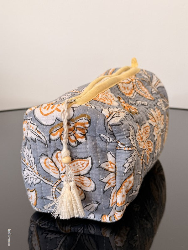 Floral-patterned fabric box with a yellow handle on a neutral background