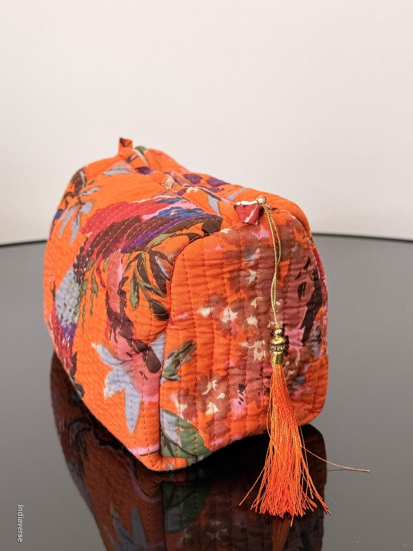 Colorful floral-patterned bag with a tassel on a plain background