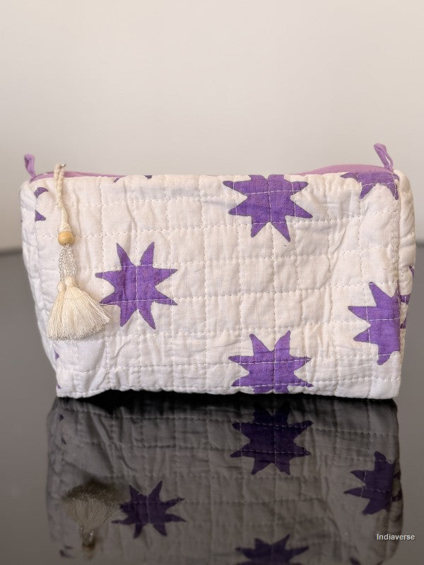 White pouch with purple star patterns on a reflective surface
