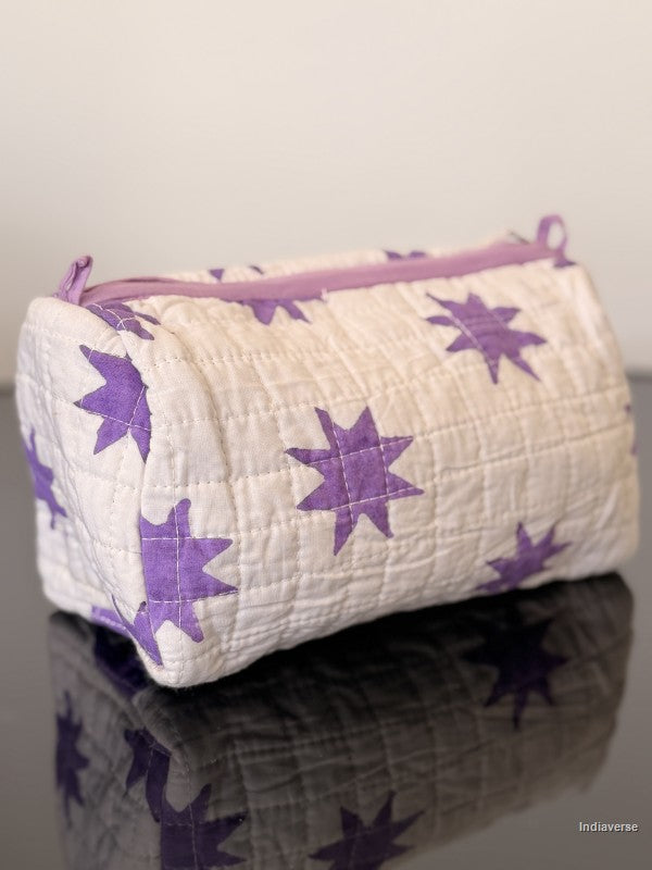 Quilted pouch with purple star pattern on a reflective surface