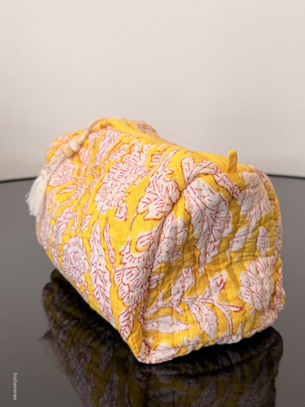 Yellow and pink patterned fabric draped over a surface with a neutral background